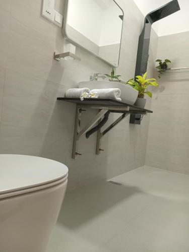 a bathroom with a white toilet and a sink at COCO Rooms in Galle