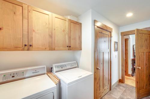 a laundry room with a washer and dryer and wooden cabinets at Chelan Mountain Retreat Chalet with Fire Pit! in Chelan