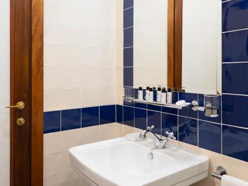 a bathroom with a sink and blue and white tiles at Borgia di Firenze in Florence