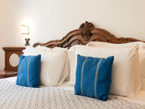 a bed with white and blue pillows on it at Borgia di Firenze in Florence