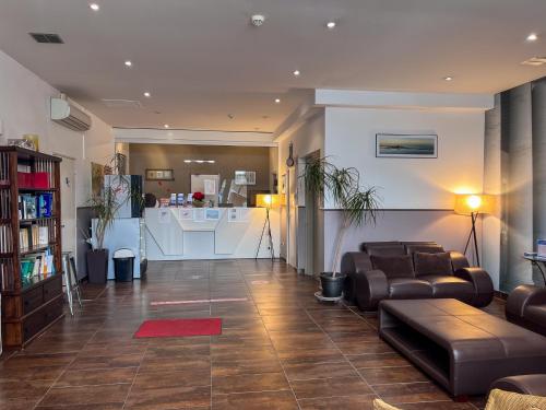 a living room with leather couches and a kitchen at Le National Sète Centre Gare,Ascenseur in Sète