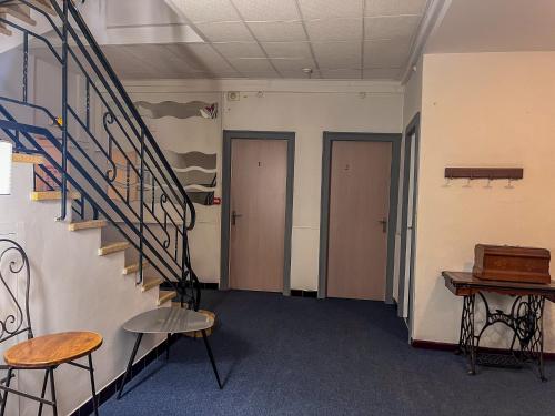 a hallway with two doors and a staircase and two chairs at Le National Sète Centre Gare,Ascenseur in Sète