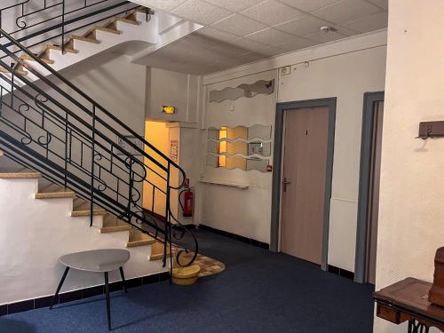 a hallway with a staircase and a table and a chair at Le National Sète Centre Gare,Ascenseur in Sète