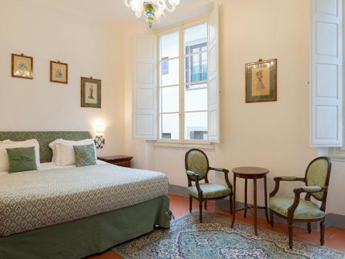 a bedroom with a bed and two chairs and a table at Borgia di Firenze in Florence