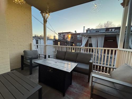 a patio with a couch and a table on a balcony at Heart of Midtown Home on Penn St - Pet Friendly in Harrisburg