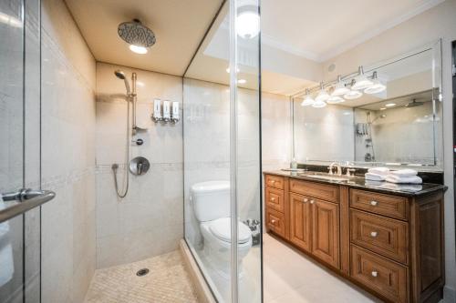 a bathroom with a shower and a toilet and a sink at StripViewSuites at Jockey Club in Las Vegas