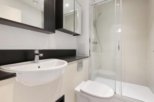 a bathroom with a sink and a toilet and a shower at London Dockside Apartment in London