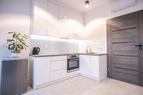 a kitchen with white cabinets and a sink at Azymut 48C in Stary Folwark