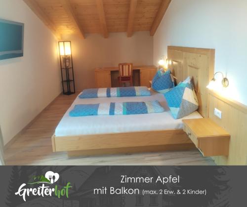 a bedroom with a large bed with blue pillows at Greiterhof Partschins in Parcines