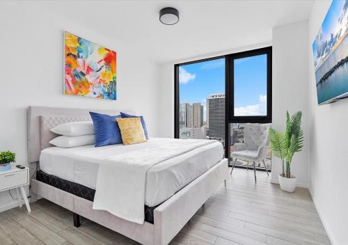 a white bedroom with a bed and a large window at X-Lounge II - Highrise in the Heart of Downtown with Rooftop Pool & Skyline Views in Miami