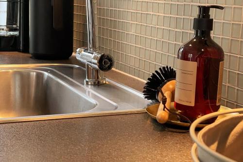 a bottle of wine sitting next to a kitchen sink at Cozy Scandinavian Apartment in the Heart of Viborg in Viborg