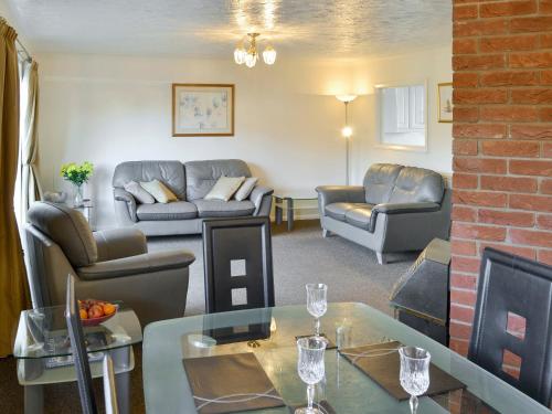 a living room with a couch and a table at Heron's Quay in Wroxham