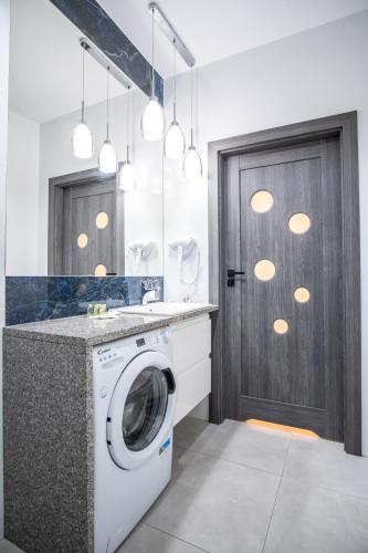 a laundry room with a washing machine and a door at Azymut 48C in Stary Folwark