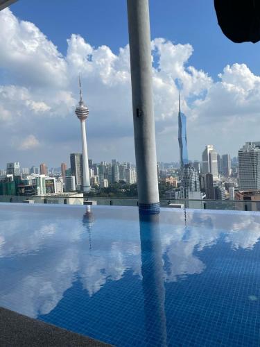 a swimming pool with a view of the city at The Luxe KLCC by Homestay in Kuala Lumpur