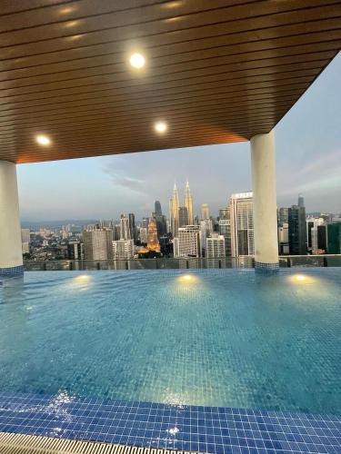 a swimming pool with a view of a city at The Luxe KLCC by Homestay in Kuala Lumpur