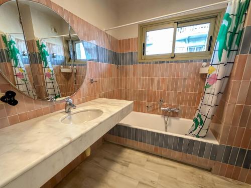 une salle de bain avec un lavabo, une baignoire et un miroir dans l'établissement Appartement lumineux, tout confort, Palais à 500 m, à Cannes