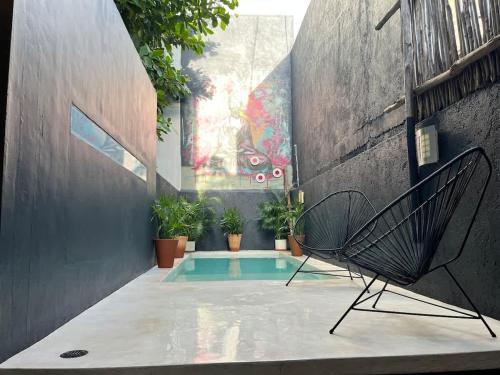 a patio with a chair next to a pool at Downtown Tulum Cozy 1bd Apartment in Tulum