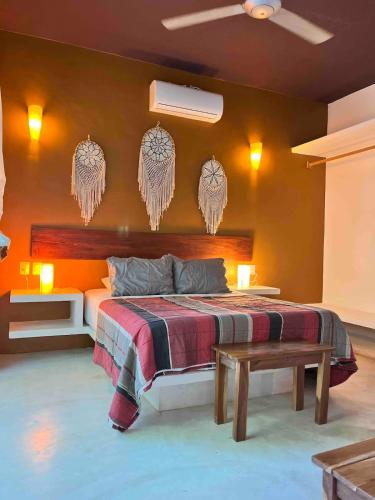 a bedroom with a large bed with orange walls at Downtown Tulum Cozy 1bd Apartment in Tulum
