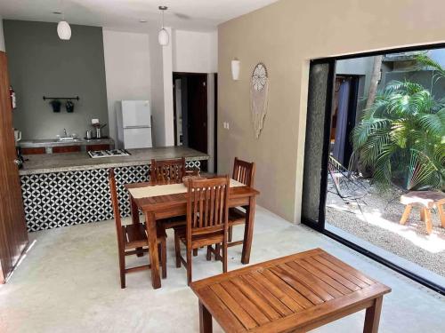 a dining room with a table and chairs and a kitchen at Downtown Tulum Cozy 1bd Apartment in Tulum