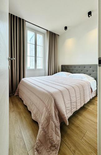 une chambre avec un grand lit et une fenêtre dans l'établissement Cozy Croisette Retreat Cannes, à Cannes