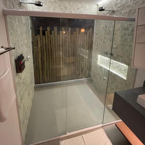 a shower with a glass door in a bathroom at Villa Canoe Hotel in Goiana