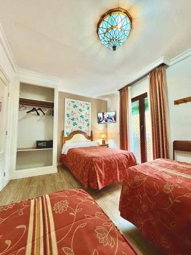a hotel room with two beds and a window at Pension Zurita in Granada