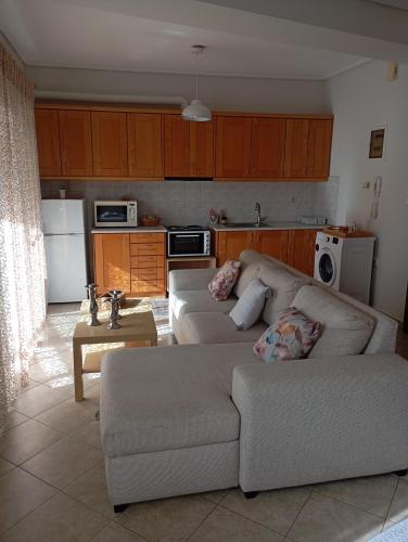 a living room with a couch and a kitchen at Volos Seaside Studio in Volos