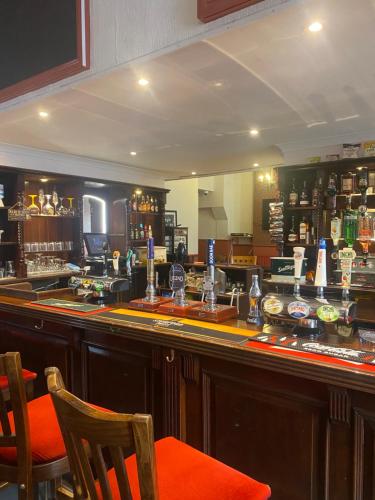 un bar con sillas naranjas y un mostrador en un pub en The keyberry, en Newton Abbot