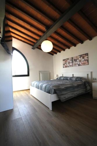 a bedroom with a large bed and a wooden floor at Casa Madrigale in San Giovanni Valdarno