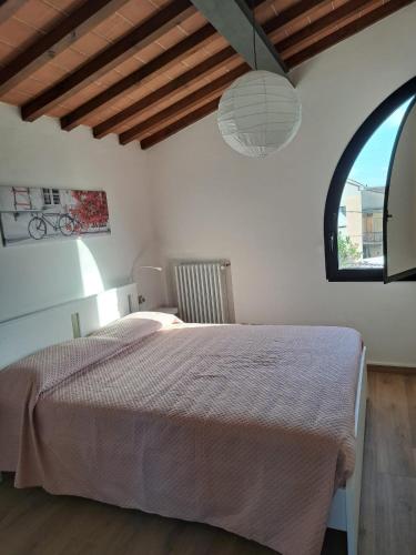 a bedroom with a large bed with a large window at Casa Madrigale in San Giovanni Valdarno