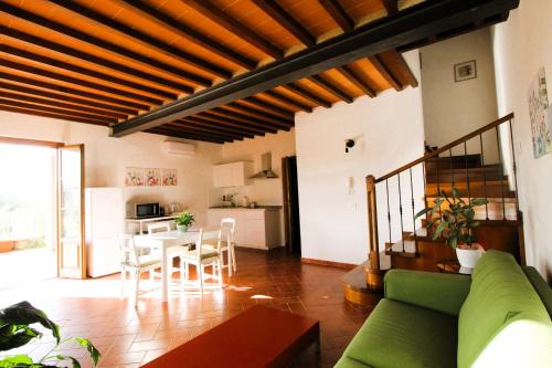 a living room with a green couch and a table at Casa Madrigale in San Giovanni Valdarno