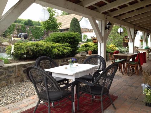 a table and chairs on a patio under a pergola at Penzion V polích in Malé Číčovice