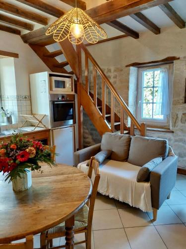 Il dispose d'une cuisine et d'un salon avec une table et un canapé. dans l'établissement Maison 2 chambres avec espace extérieur privé et petit-déjeuner en supplément - fait-maison et produits locaux, à Vierville-sur-Mer