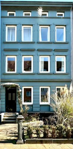 a blue building with white windows on the side of it at Boutique Apartment im charmanten Altbau in Lübeck