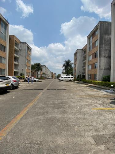 an empty parking lot with parked cars and buildings at Apartaestudio central en Conjunto residencial in Ibagué