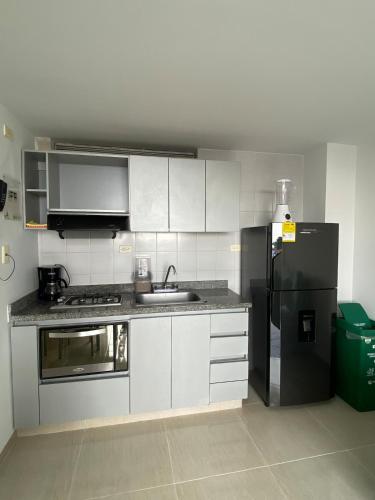 a kitchen with a sink and a refrigerator at Apartaestudio central en Conjunto residencial in Ibagué