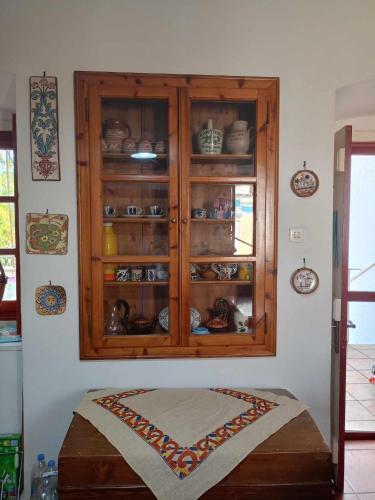 a wooden cabinet with dishes in it on a wall at LILIA in Poros
