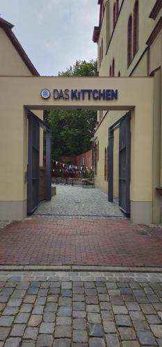 a building with a sign that reads dogs kitchen at Das Kittchen in Wismar