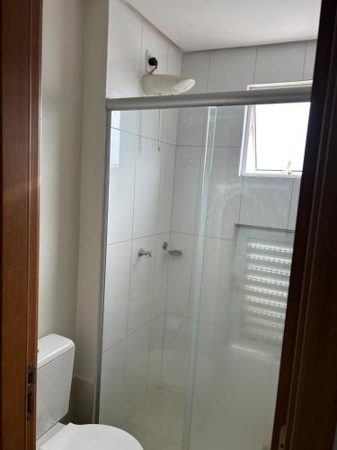 a bathroom with a glass shower with a toilet at Flat completo com linda vista in Palmas