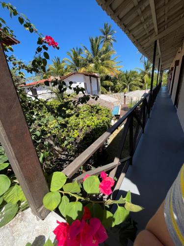 a balcony with pink flowers on a beach at Pousada Altas Horas Icaraizinho in Icaraí