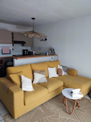 a yellow couch in a living room with a table at la détente in Berck-sur-Mer