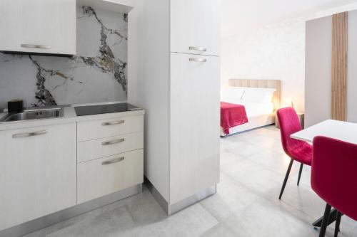 a kitchen with a sink and a table and a bed at Perlanera appartamenti in Trani