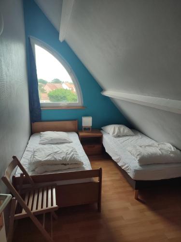 two beds in a room with a window at la détente in Berck-sur-Mer
