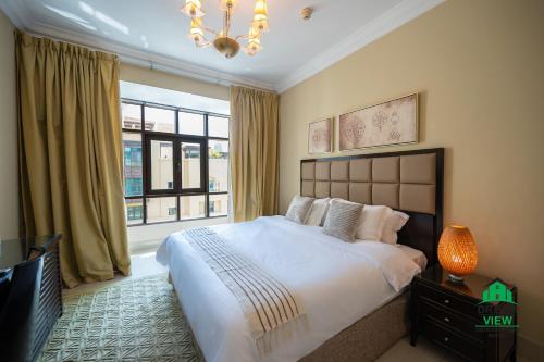 a bedroom with a large bed and a window at Souk Al Bahar - Burj Khalifa - Dream View Holiday Home Rental in Dubai