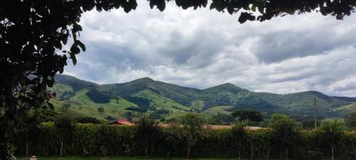 a view of green mountains on a cloudy day at Chalé de alto padrão em condomínio in Santa Rita do Sapucaí