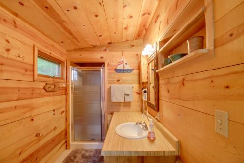 a bathroom with a sink in a log cabin at Quiet Deer River Cabin with Dock and Lake View! in Deer River