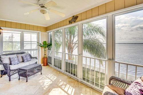 a screened in porch with a couch and chairs at Condo on St Johns River with Boat Dock Access! in Welaka