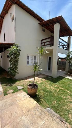 a house with a potted plant in the yard at Casa Sol Canoa Quebrada in Canoa Quebrada