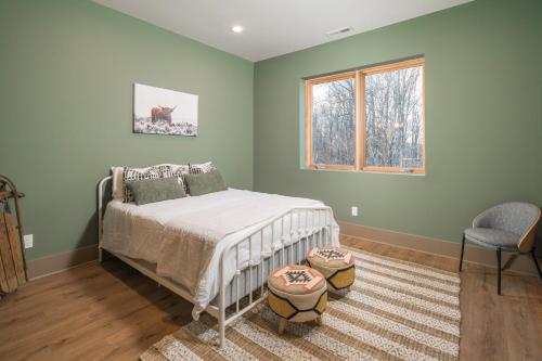 a bedroom with a bed and a window and a chair at Group Getaway! 8,000-Sq-Ft Gem, Arcade + Theater in Beech Mountain