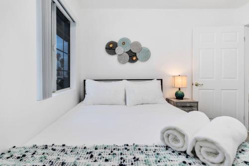 a white bedroom with a white bed and a window at 6 Mi to Joshua Tree Home with Outdoor Oasis and View! in Twentynine Palms